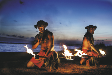 Feuertaenzer bei Nacht am Strand in Hawaii